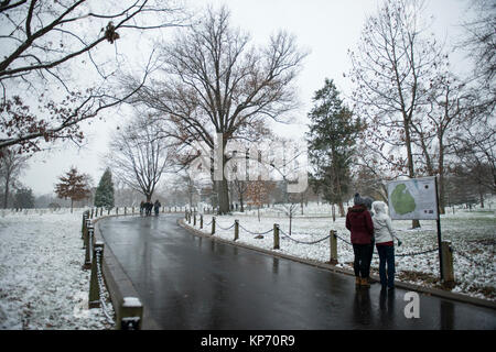 Visitors look at a map on the pathway leading to John .F Kennedy's gravesite during the first snow of the season at Arlington National Cemetery, Arlington, Virginia, Dec. 9, 2017.  (U.S. Army Stock Photo