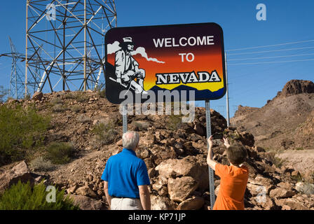 Senior couple snapping photo of welcome to Nevada sign, USA. Stock Photo