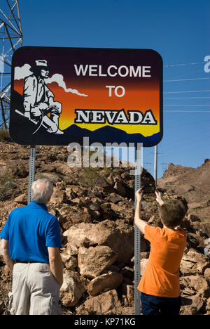 Senior couple snapping photo of welcome to Nevada sign, USA. Stock Photo