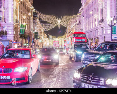 Busy crossroads at Piccadilly Circus looking towards Regent Street St James with the Christmas 'Angel' hanging overhead, London. Stock Photo