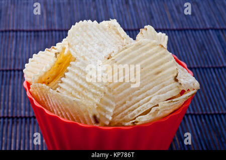 fried potato chips in red plastic bowl Stock Photo