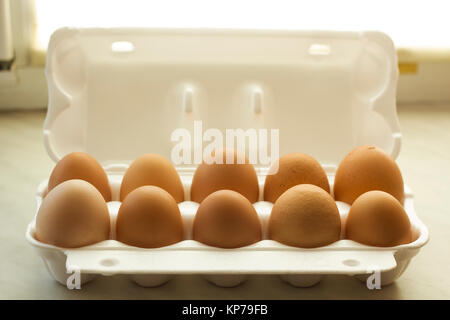 Ten chicken eggs brown color in white open foam packaging Stock Photo