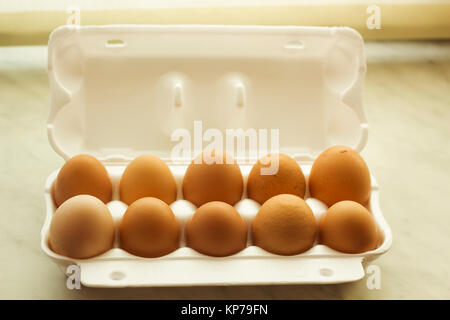 Ten chicken eggs brown color in white open foam packaging Stock Photo
