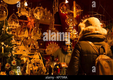 Christmas market in Basel, Switzerland. 9th of December 2017. A woman is buying traditional wooden christmas decorations made in Germany at one of the Stock Photo