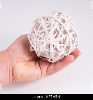 a sphere formed with white colored wooden sprigs in the hand Stock Photo