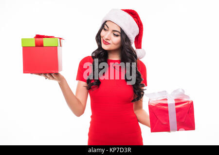 Beauty woman in red dress and santa hat holding gifts on balance on white Stock Photo