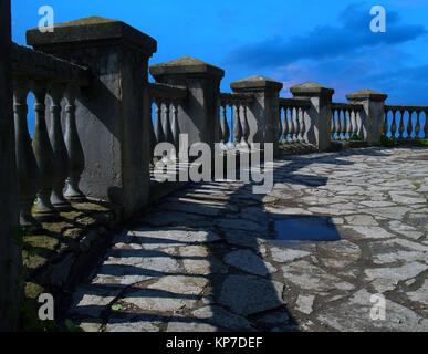 Old stone balustrade, a fence on a background of a bright blue sky. Stock Photo