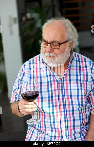 Mature man drinking wine at home Stock Photo