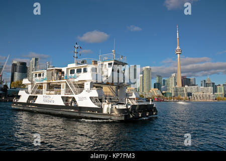 Toronto Billy Bishop Toronto City Airport mainland lounge with passenger ferry coming towards the island with downtown skyline under blue sky white cl Stock Photo