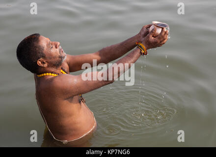 A pilgrim praying in the River Ganges at Varanasi Stock Photo