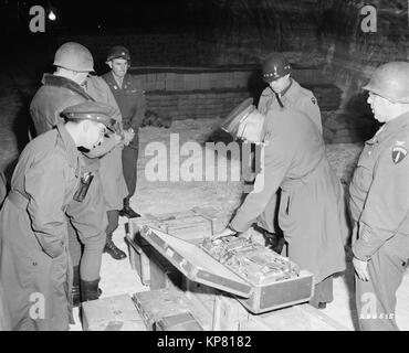 Gen. Dwight D. Eisenhower, Supreme Allied Commander, and Gen. Omar N. Bradley, CG, 12th Army Group, examine a suitcase of silverware, part of German loot stored in a salt mine. Photographer: Lt. Moore 04/12/1945 111-SC-204515 Stock Photo