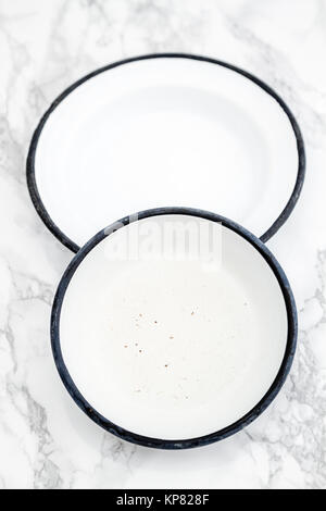 Empty White Vintage Enamel Plates on Marble Stock Photo