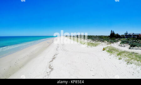 Drone aerial view of wide open white sandy beach, taken at Tennyson, South Australia with nearby luxury two story homes overlooking the coast. Stock Photo