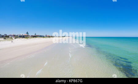 Drone aerial view of wide open white sandy beach, taken at Tennyson, South Australia with nearby luxury two story homes overlooking the coast. Stock Photo