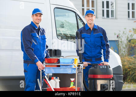 Happy Janitors Standing Against Truck Stock Photo