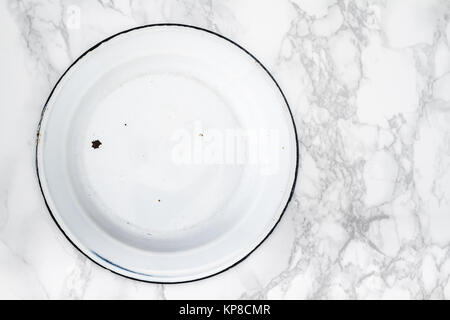Back Side of Empty White Vintage Enamel Plates on Marble Stock Photo