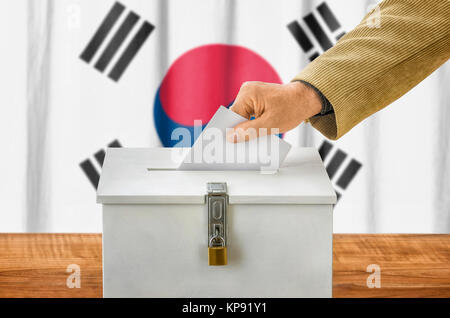 man putting ballot in the ballot box - south korea Stock Photo