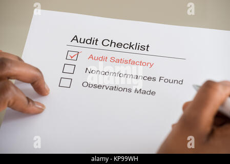 Audit checklist and human hand with pencil Stock Photo - Alamy