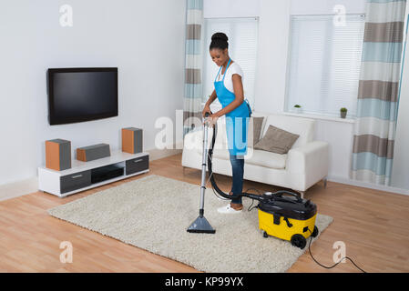 Woman Cleaning Carpet With Vacuum Cleaner Stock Photo
