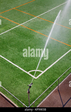 Irrigation sprinkler system working at sport field. Green color background Stock Photo