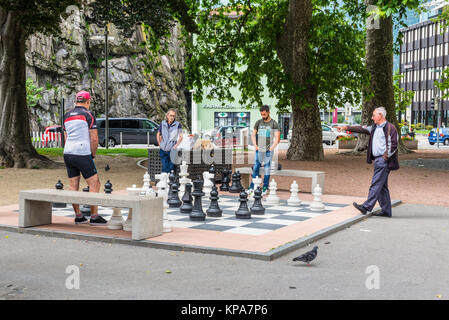 Bellinzona, Switzerland - May 28, 2016: Men playing outdoor chess on a life size board in Bellinzona, Switzerland. Stock Photo