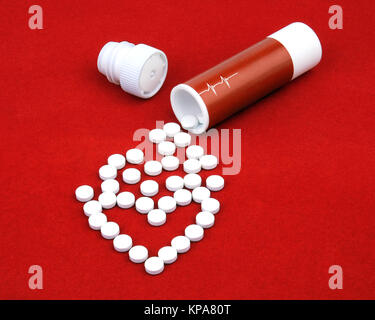 The tablets from heart disease spill out of boxes on a red velvet. Stock Photo