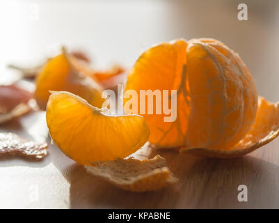 Peeled tangerine and segment backlit from the sun Stock Photo