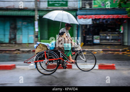 passenger is riding rickshaw on the road Stock Photo