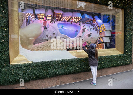 An unidentified young girl touches the window of a  Macy's Christmas display at Herald Square in Manhattan, New York City. Stock Photo