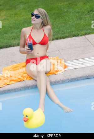 Model release, Junge Frau im Bikini trinkt Cocktail am Pool - woman with cocktail at pool Stock Photo