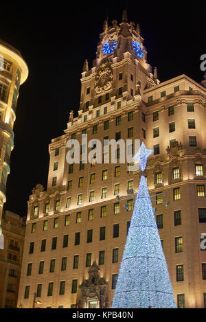 Telefonica building in Gran Via street of Madrid with a shinny christmas tree in foreground. Madrid, Spain. Stock Photo