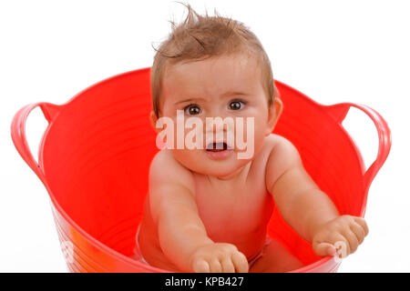 Model release, Kleinkind, 8 Monate, sitzt in roter Wanne - little child in red tub Stock Photo