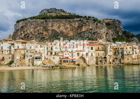 Beach of cefalu with its old constructions and in the background a great formation known as the rock on the same are the ruins of the ancient temple o Stock Photo