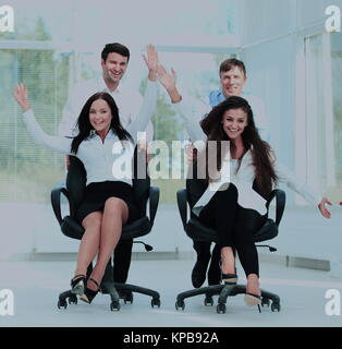 Smiling partners playing together with swivel chair in the offic Stock Photo