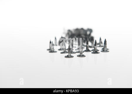 A pile of felt nails with points showing on a white background possible concept usage. Stock Photo