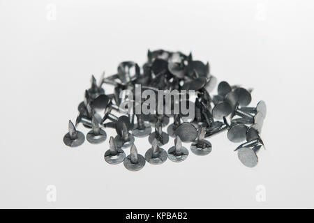 A pile of felt nails with points showing on a white background possible concept usage. Stock Photo