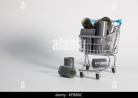 Shopping trolley and tangle of unrolled exposed 35mm film strips over a white background in a retro photography concept Stock Photo