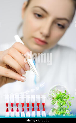 PCR control of bacterial contamination in cress-salat for general consumption, face of young tech out of focus. Shallow DOF, focus on the hand with tw Stock Photo