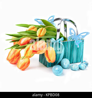 Easter basket with tulips, eggs, ribbons and wooden butterflies on white background Stock Photo