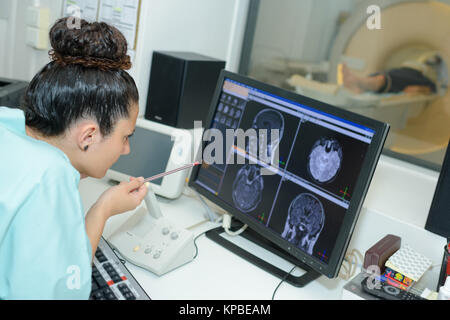 doctor checkin brain scans on screen Stock Photo
