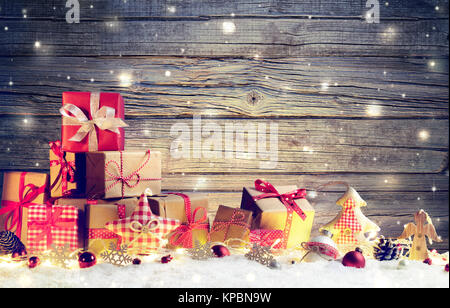 Rustic Gift Boxes On Snow With Christmas Ornament And Wooden Background Stock Photo