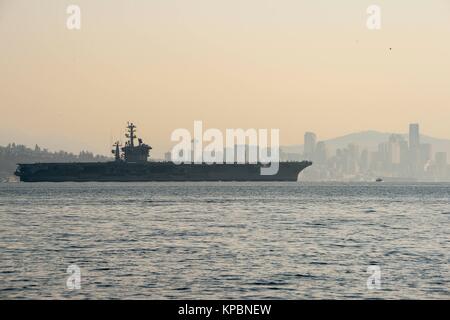 The U.S. Navy Nimitz-class aircraft carrier USS Nimitz transits the Puget Sound on its way back home to the Naval Base Kitsap December 10, 2017 in Bainbridge Island, Washington. Stock Photo