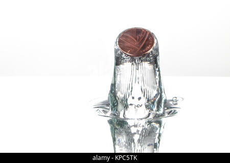 Coin splash in water caught with high speed photography, on a white background Stock Photo