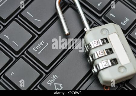 Opened padlock on new black computer keyboard in background. Stock Photo