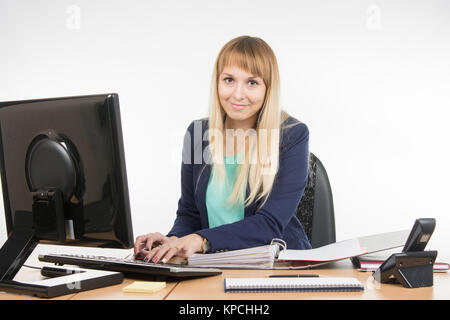 Secretary working in the computer, close the folder with the documents is Stock Photo
