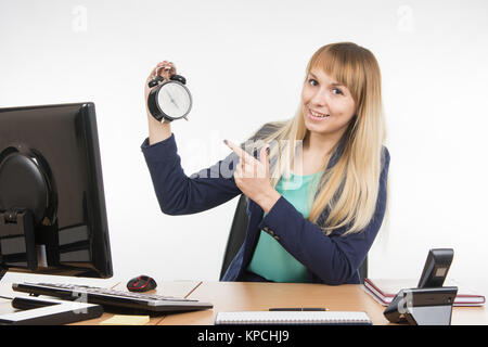 Office specialist in after-hours shows the clock Stock Photo
