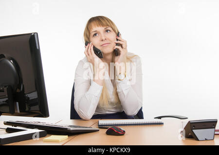 Secretary talking on two phones at once - and the working cell Stock Photo