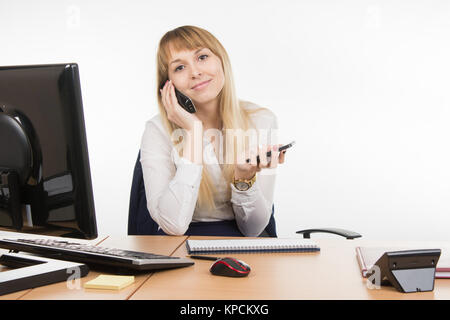 Happy secretary talking on the phone and working holding cell Stock Photo