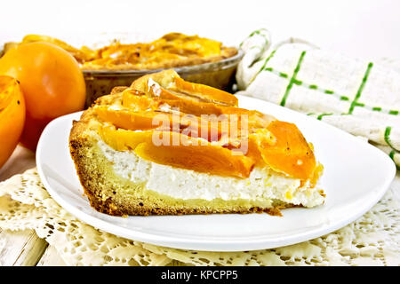 Pie with curd and persimmons in plate on napkin Stock Photo