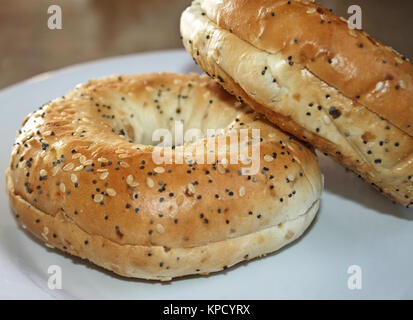 Two wholegrain bagels covered with sesame and poppy seeds Stock Photo